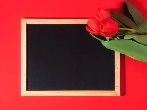 Fondo San Valentín con tulipanes rojos y pizarra vacía — Foto de Stock
