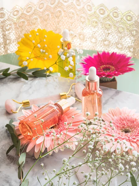 Cosmetic serum bottle and pink quartz face roller guasha — Stock Photo, Image