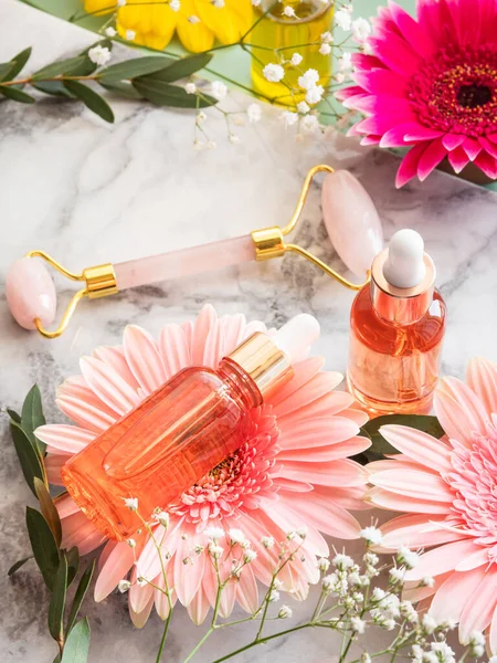 Cosmetic serum bottle and pink quartz face roller guasha — Stock Photo, Image