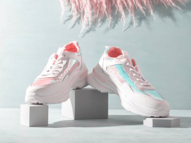 Geometrik podyumlarda pembe pampa otlu pullu beyaz pastel ayakkabılar. Moda konsepti