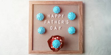 Babalar Günü tebrik kartı, üzerinde yazı ve turkuaz gri arka planda mavi tatlı kremalar. Düz yatıyordu