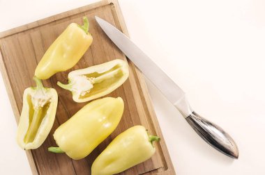 sweet yellow pepper on wooden board isolated on a white background - top view flat lay