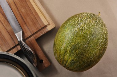 whole green melon on a background of craft paper - top view flat lay