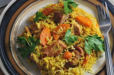 pilaf in a plate - a dish with meat, carrots and rice - top view flat layer