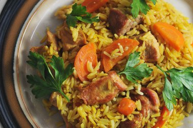 pilaf in a plate - a dish with meat, carrots and rice - top view flat layer