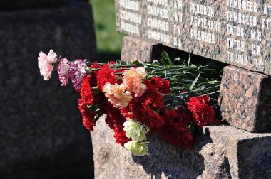 flowers on the monument dedicated to the victims of World War II-Victory Day-May 9. on the marble are military ranks and surnames, such as Private Timofeev, Lieutenant Titov, Private Tishin etc.
