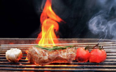 Kavrulmuş biftek, biberiye, domates ve sarımsak, yanan kömür ızgarasında duman ve siyah arka planda ateş alevi. 