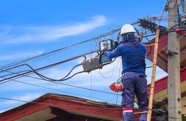 Ağ bağlantısından sonra internet sinyal test cihazının görüntüsünü kaydetmek için akıllı telefonu kullanan ahşap merdivendeki teknisyen tamamen.