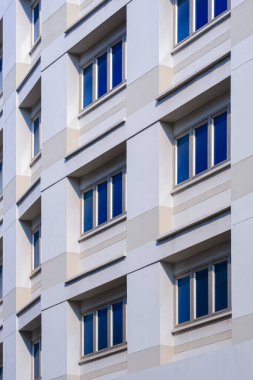 Ofis duvarındaki dikey çerçevede birden fazla mavi pencerenin düşük açı ve perspektif kenar görüntüsü