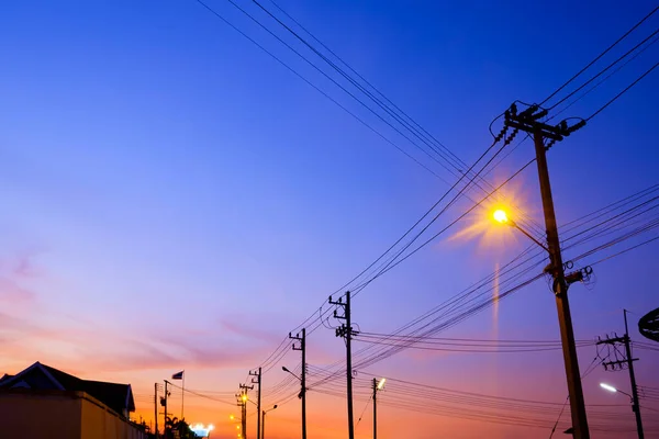 Silhouette Von Strommasten Mit Hochspannungsleitungen Vor Buntem Dämmerhimmel Hintergrund Tiefansicht — Stockfoto