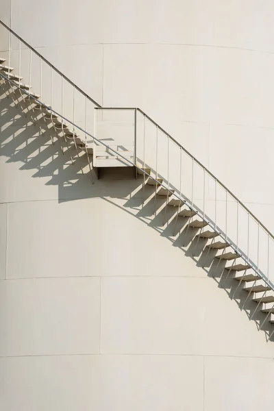 垂直フレーム内の石油貯蔵燃料タンク上のスパイラル階段の曲線 — ストック写真