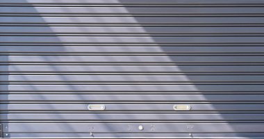 Otomatik gri metal kapaklı kapaklı arka plan. Güneş ışığı ve yüzeyinde gölge var.