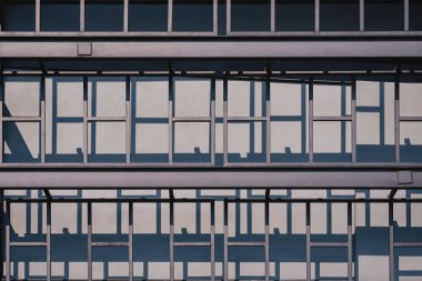 Modern çelik yapı evinin dışında endüstriyel çatı katı tarzında siyah metal duvar dekorasyonunda güneş ışığı ve gölge.