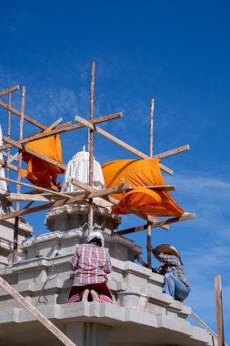 Asyalı iki kadın zanaatkar, Tayland tapınak bölgesindeki hareket edebilen kemerli kapı yapısında geleneksel kalıplar çıkarıyorlar.