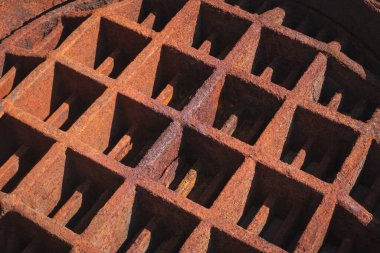 Light and shadow on backside surface of the old rusty manhole cover