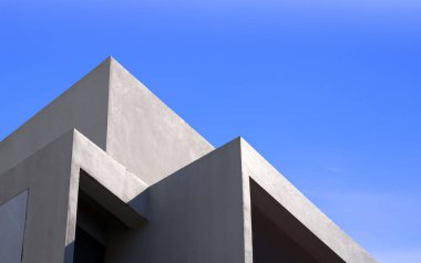 Modern bej binanın düşük açılı ve perspektifli mavi gökyüzüne karşı minimal geometrik mimari arka planı