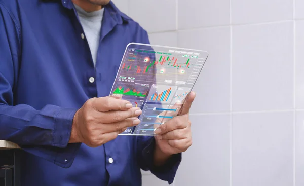 Adult man using futuristic transparent tablet to checking and analysis cryptocurrency online trading platform with financial data stock market