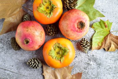 Zirve manzarası, nar ve hurma ağaçları, yapraklar ve ananaslar dağınık dış hatlar ve taş zemin. Sağlıklı ve sonbahar yemekleri..