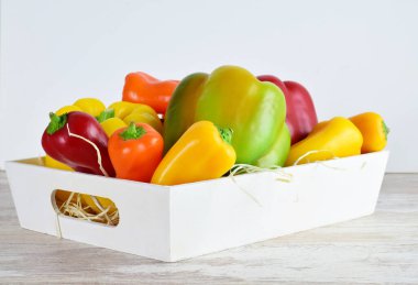 Beyaz tahta bir kutuda çeşitli biberler, açık renkli taban ve taban..