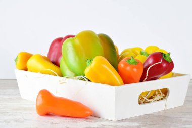 Beyaz tahta bir kutuda çeşitli biberler, açık renkli taban ve taban.