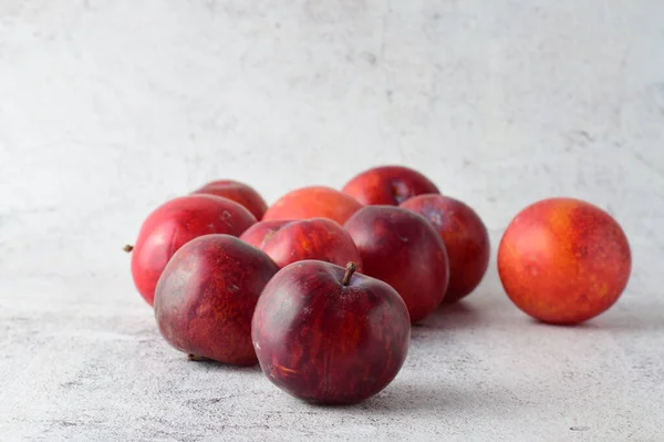 Gros Plan Prunes Rouges Éparpillées Sur Fond Pierre Grise — Photo