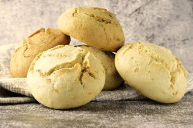 Kapatın. Taştan bir arka planda, malzemeli çeşitli ekmekler, taze pişmiş. Cevizli, kuru üzümlü ve zeytinli soğan aromalı..