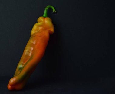 Siyah arkaplanda çeşitli renkte dolma biber.