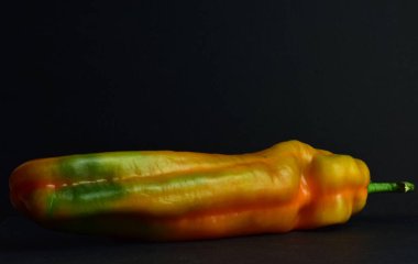 Yakın plan, siyah arkaplanda çeşitli renkte dolma biber.