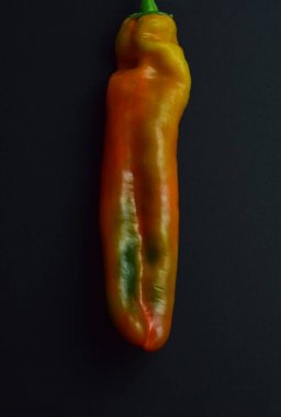 Siyah arkaplanda çeşitli renkte dolma biber.