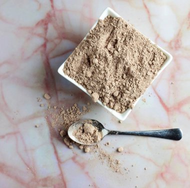 Zenith manzaralı, çikolata tozlu kaşık, mermer üzerinde küçük porselen kâsenin yanında soyut şekilli..