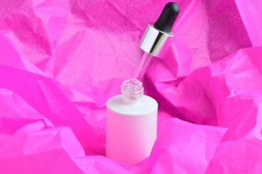 Pembe arkaplandaki Drip kozmetik kabı.