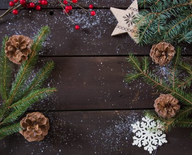 Koyu kahverengi ahşap üzerine noel süslemeleri kar ve köknar dalları ile metin arkaplanı için alan.