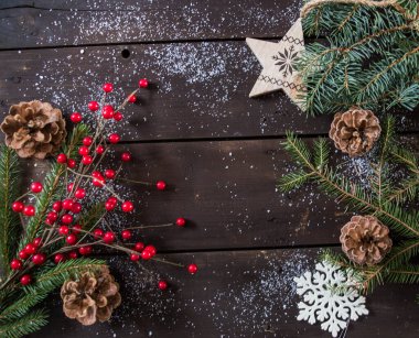 Koyu kahverengi ahşap üzerine noel süslemeleri kar ve köknar dalları ile metin arkaplanı için alan.