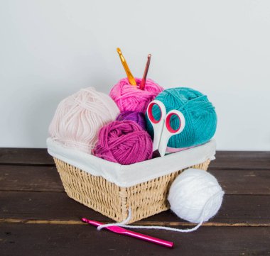 Koyu kahverengi ahşap zeminde el yapımı renkli yün toplar.