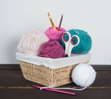 Koyu kahverengi ahşap zeminde el yapımı renkli yün toplar.