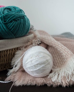 Koyu kahverengi ahşap zeminde el yapımı renkli yün toplar.