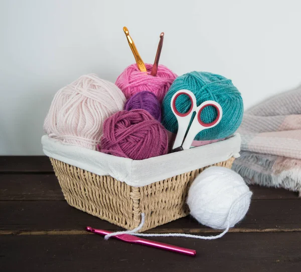 Koyu kahverengi ahşap zeminde el yapımı renkli yün toplar.