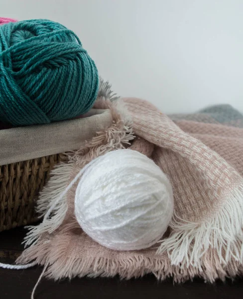 Koyu kahverengi ahşap zeminde el yapımı renkli yün toplar.