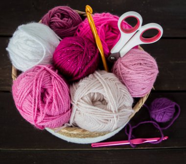 Koyu kahverengi ahşap zeminde el yapımı renkli yün toplar.