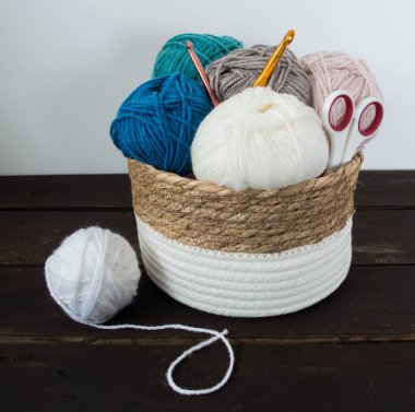 Koyu kahverengi ahşap zeminde el yapımı renkli yün toplar.