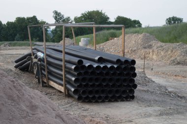 İnşaat alanında bir yığın siyah kanal.