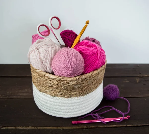 Koyu kahverengi ahşap zeminde el yapımı renkli yün toplar.