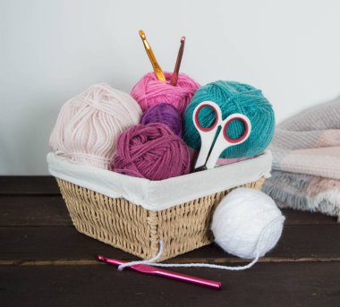 Koyu kahverengi ahşap zeminde el yapımı renkli yün toplar.