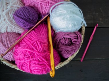 Koyu kahverengi ahşap zeminde el yapımı renkli yün toplar.