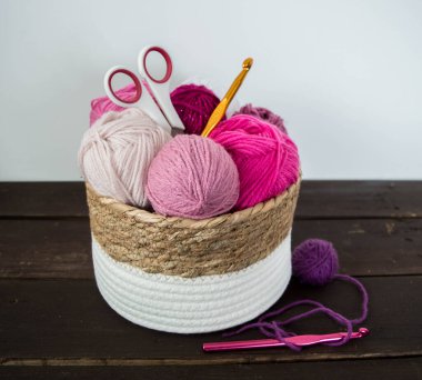 Koyu kahverengi ahşap zeminde el yapımı renkli yün toplar.