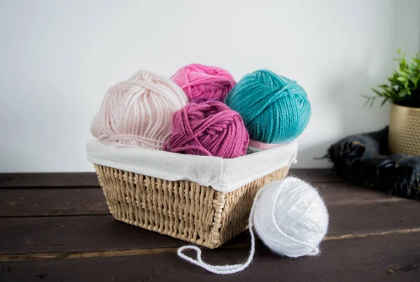 Koyu kahverengi ahşap zeminde el yapımı renkli yün toplar.