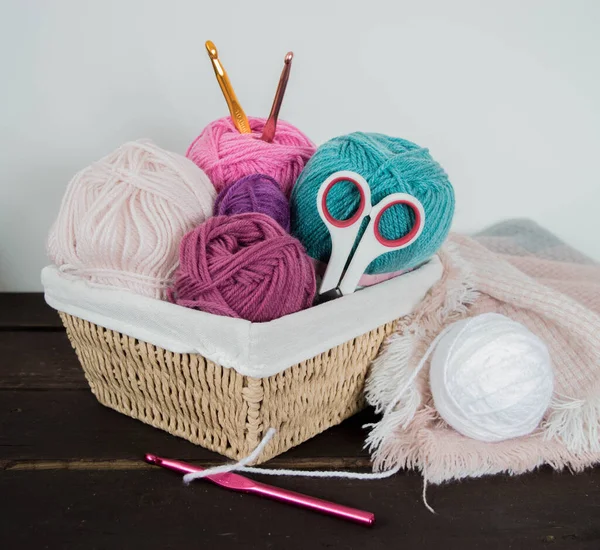 Koyu kahverengi ahşap zeminde el yapımı renkli yün toplar.