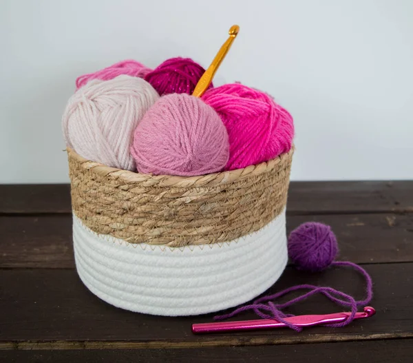 Koyu kahverengi ahşap zeminde el yapımı renkli yün toplar.