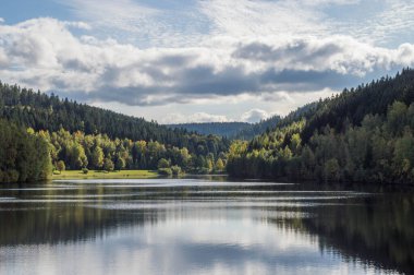 Sonbahar manzarasında güzel bir günde mavi gökyüzü ve bulutlu bir baraj.