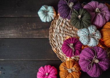 Koyu kahverengi ahşap zemin üzerinde ışıkları olan el yapımı tığ işi balkabakları.